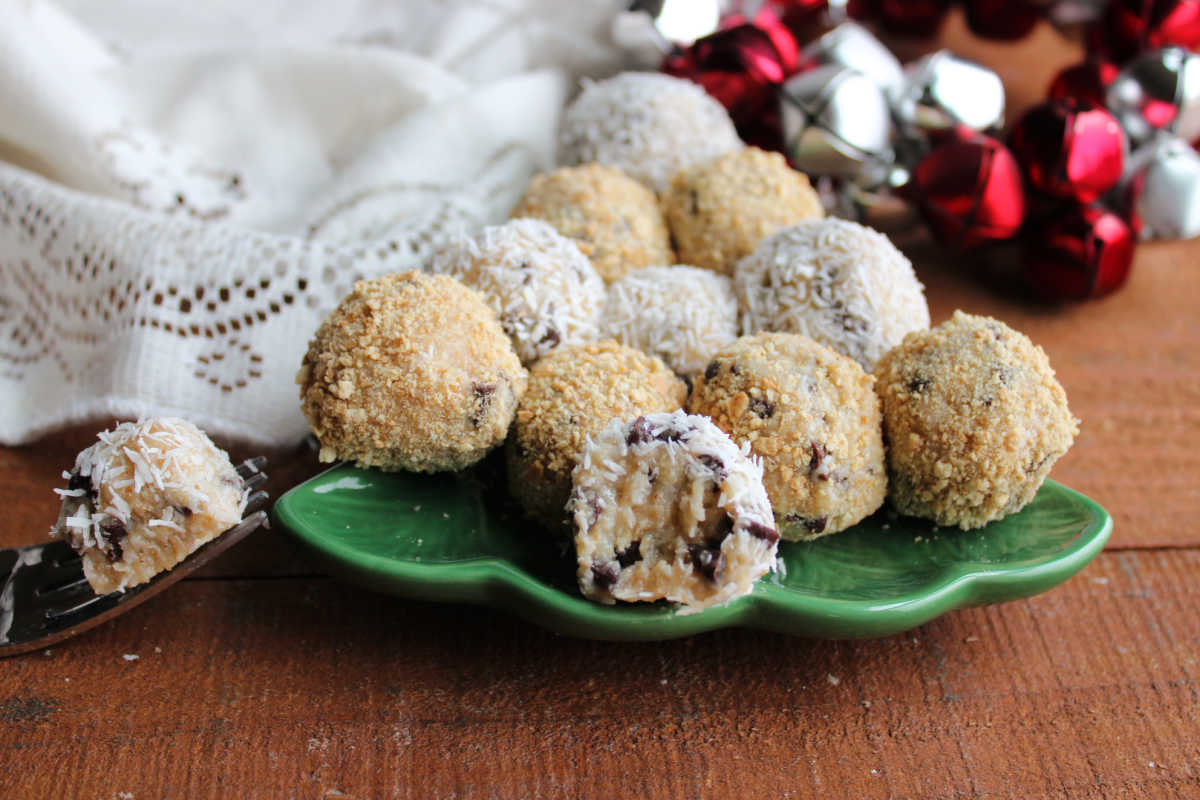 Small plate of moose farts, one that has been cut in half with fork showing the creamy inside with bits of chocolate chips, graham cracker and coconut in creamy base. 