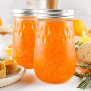 Two jars of homemade orange marmalade, ready to use.