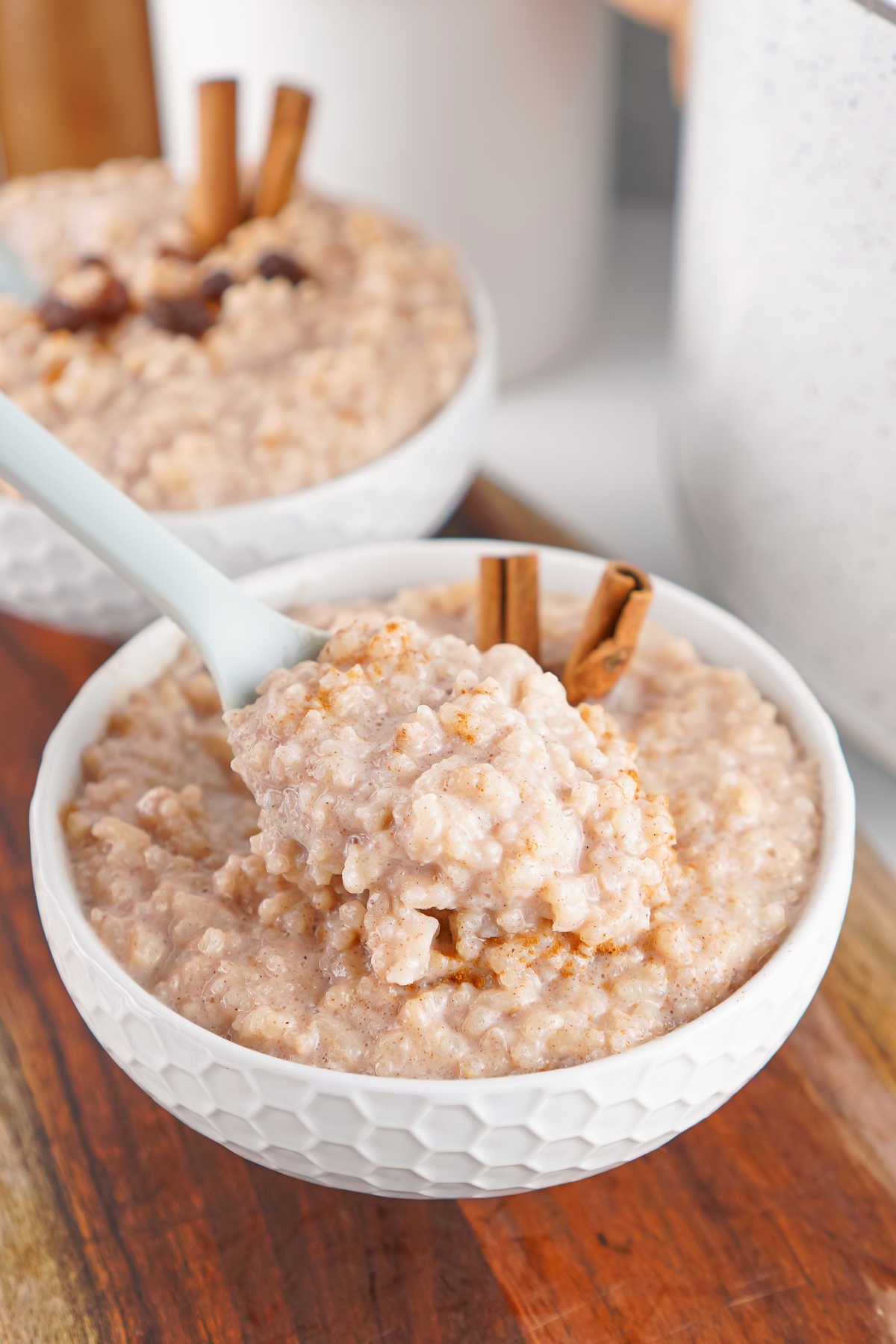 Bite of creamy crockpot rice pudding on a spoon, ready to eat. 