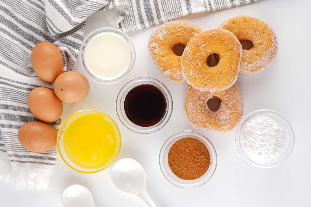 Donut Bread Pudding 6 Ingredients including stale donuts, milk, eggs, melted butter, cinnamon, vanilla, and powdered sugar ready to be made into donut bread pudding.