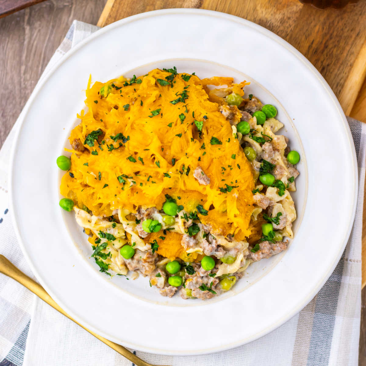 Amish Country Casserole 7 Plate of amish country casserole with egg noodles in cream of mushroom sauce with ground beef and peas with melted cheese over everything.