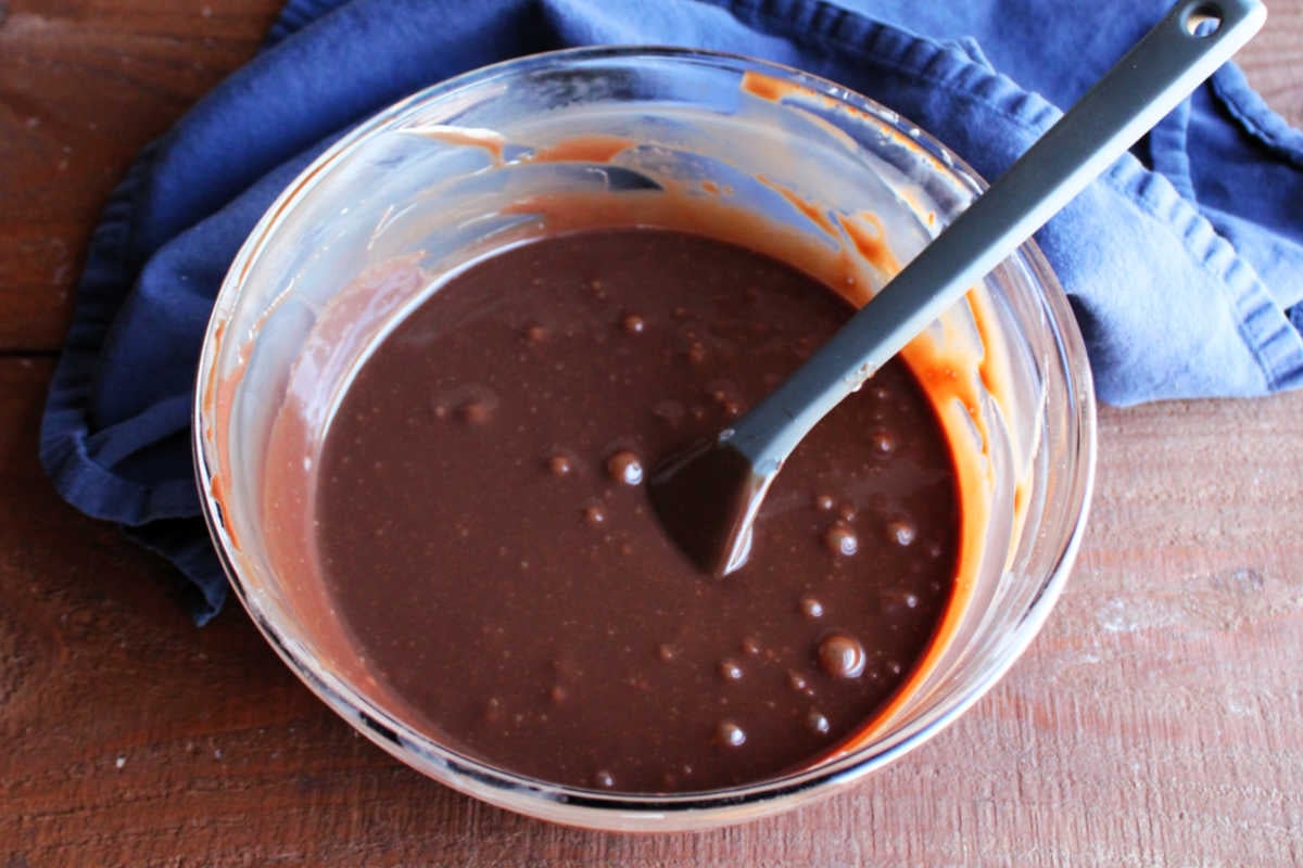 Bowl of condensed milk, chocolate chips, and butter melted together into a smooth hot fudge sauce. 