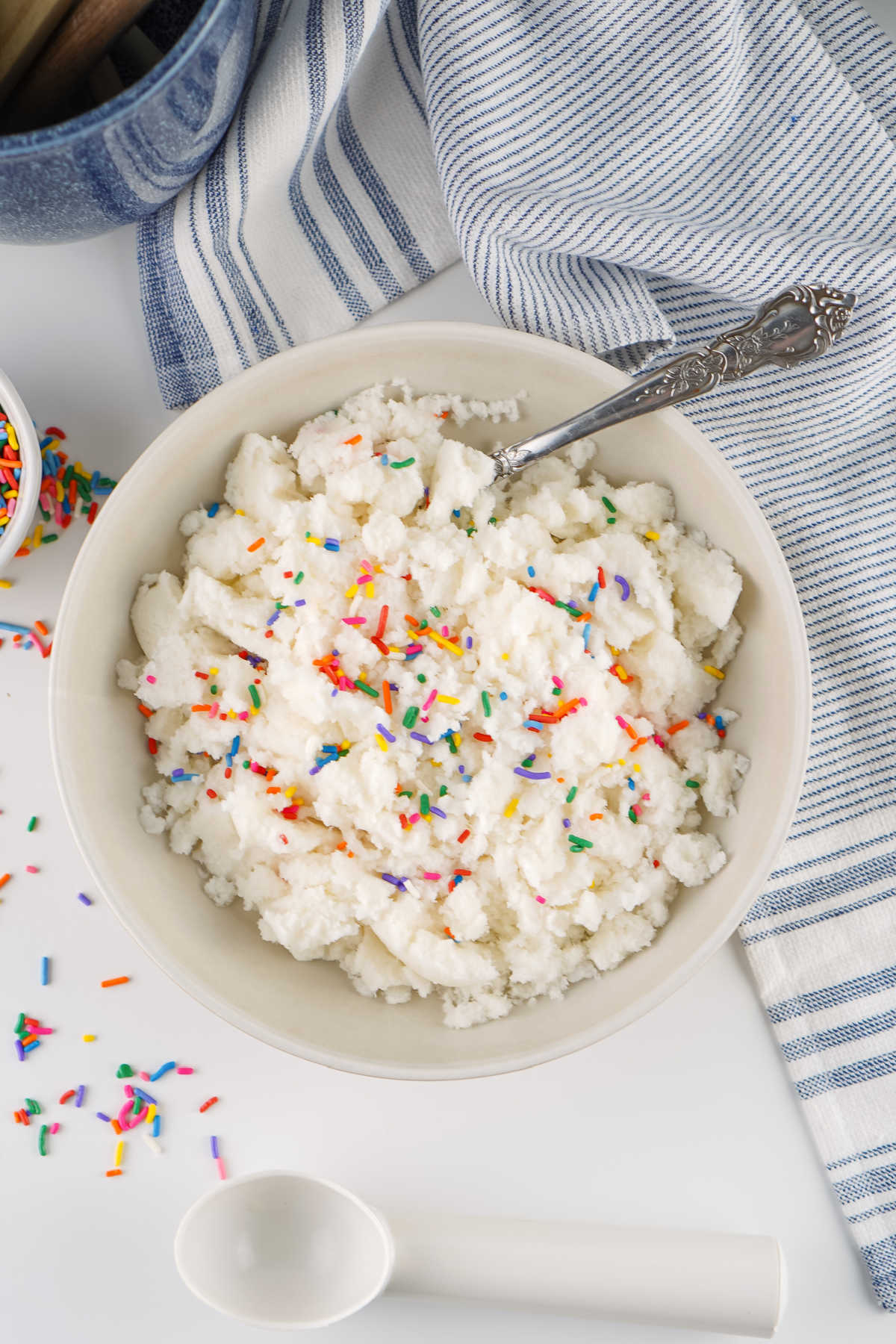 Bowl of fresh snow ice cream that is shaggy from just being stirred together topped with sprinkles. 