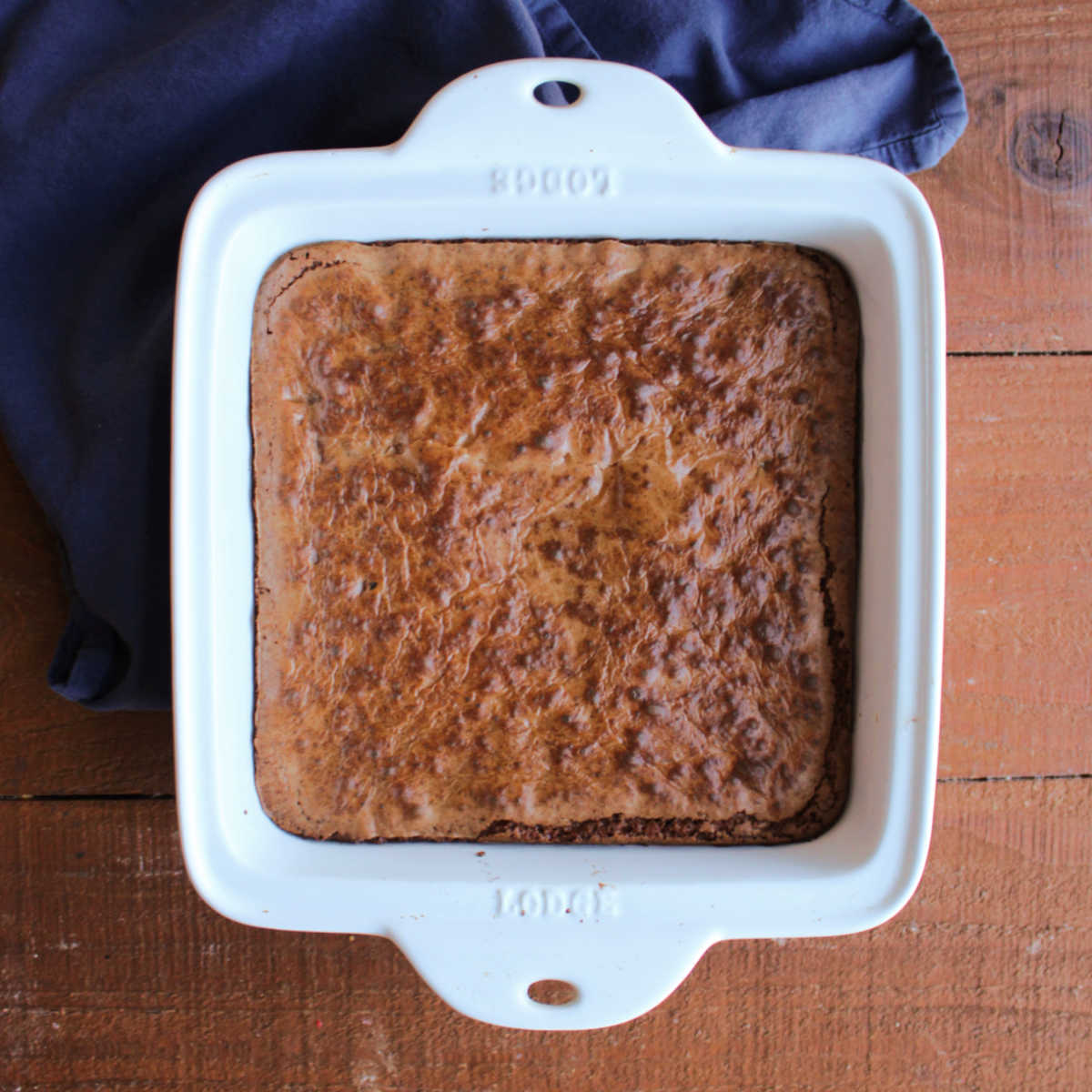 Square baking dish with batch of freshly baked prune brownies inside. 