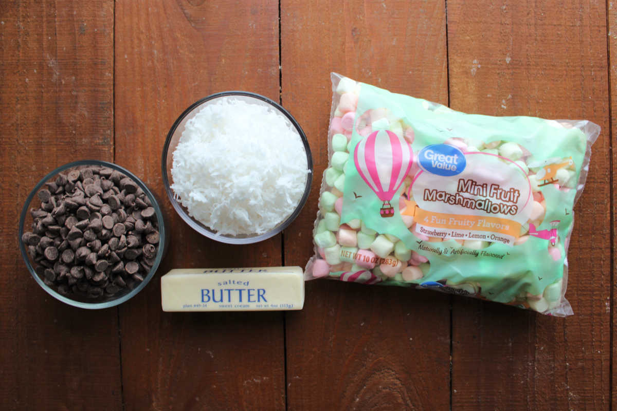 Ingredients including semisweet chocolate chips, butter, flaked coconut, and fruity pastel marshmallows ready to be made into stained glass cookies. 