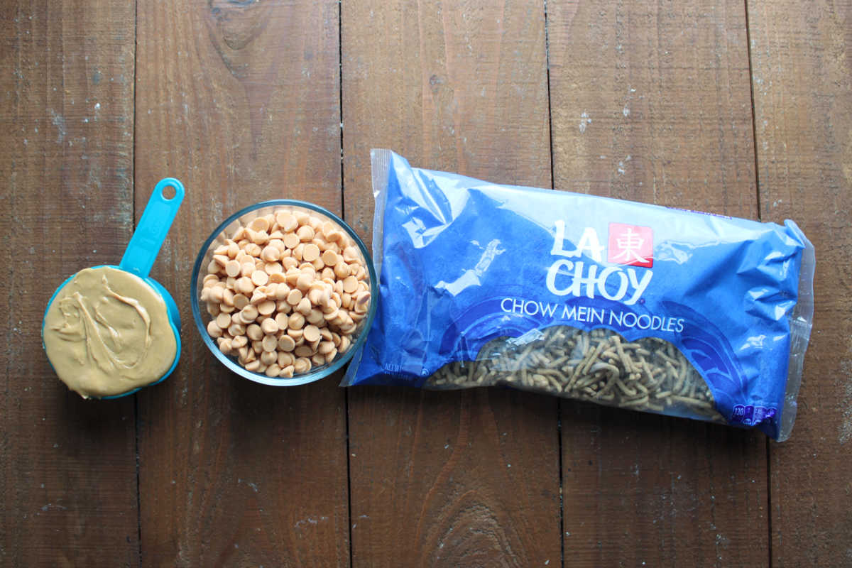 Ingredients including creamy peanut butter, butterscotch chips, and a bag of crunchy chow mein noodles. 