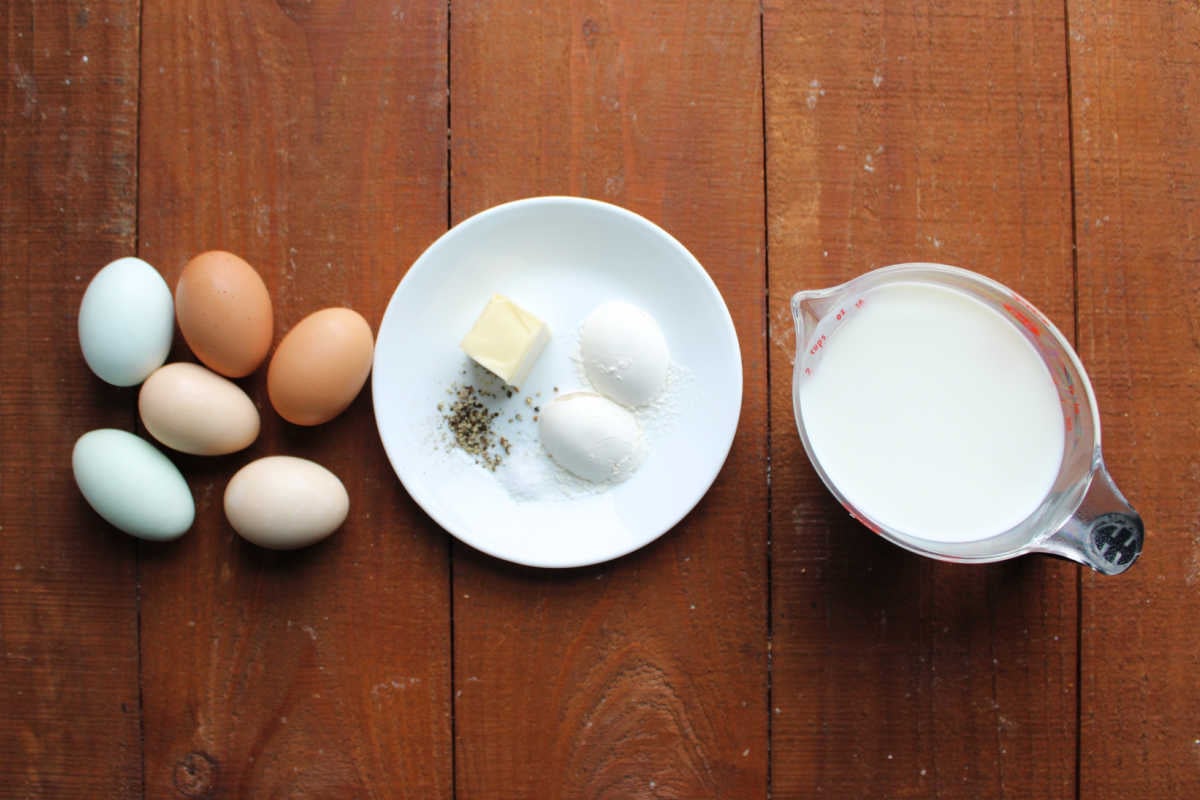 Ingredients including hard boiled eggs, butter, flour, salt, pepper and milk ready to be made into egg gravy. 