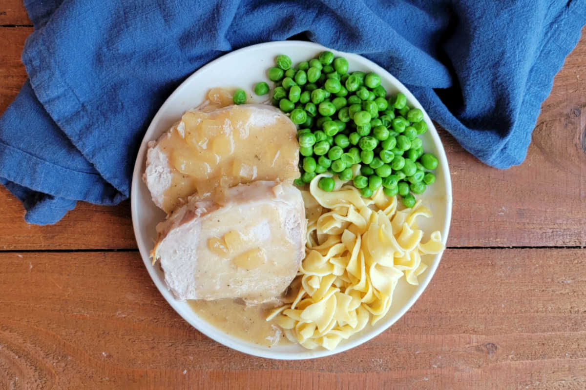 Dinner plate with honey mustard pork loin served with noodles and peas, ready to eat. 