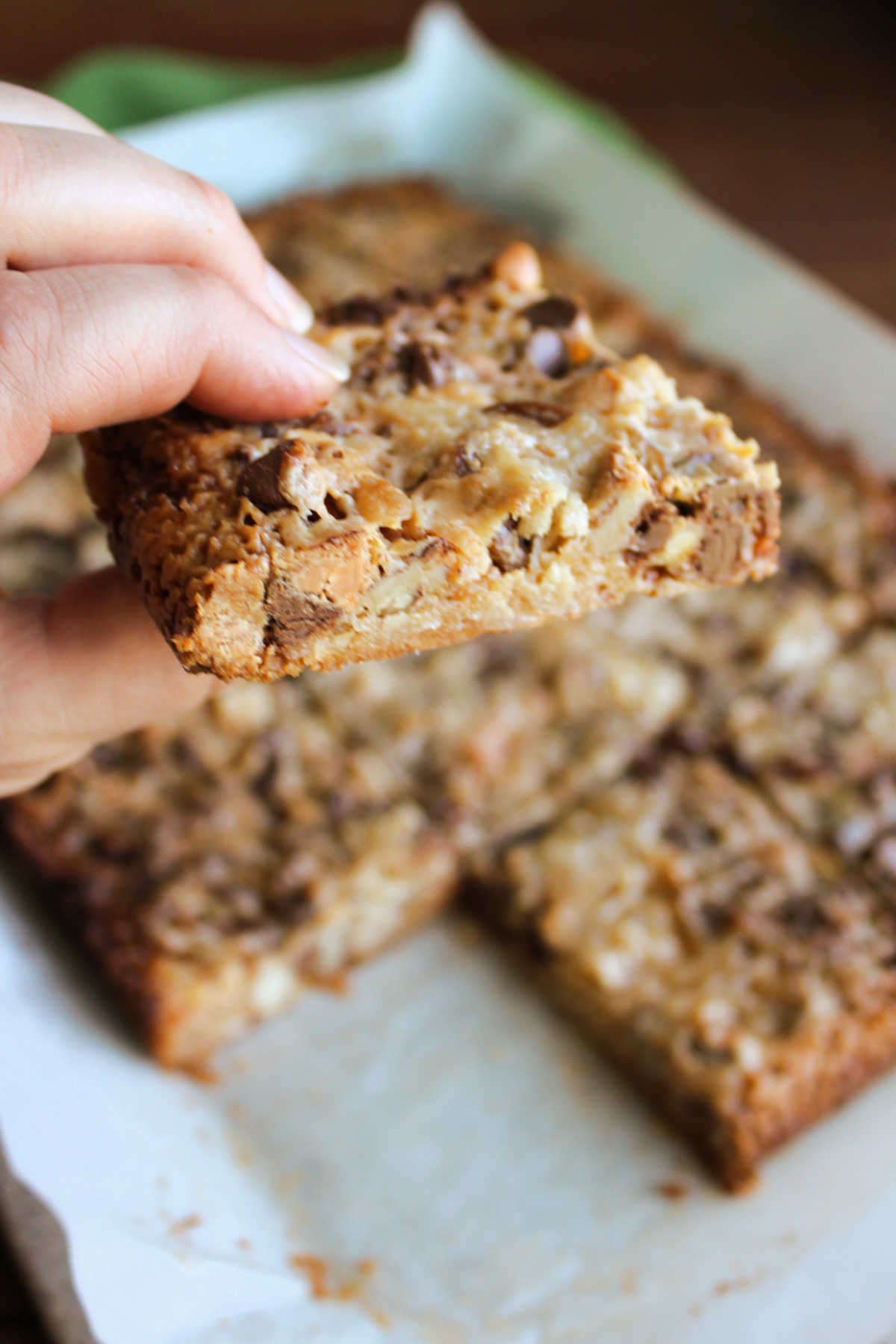 Hand holding a dippy chippy square showing how everything came together in a cohesive bar and caramelized a bit in the oven. 