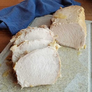 Sliced honey mustard pork loin on cutting board.