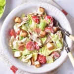 Bowl of BLT salad with lettuce, cherry tomatoes, bacon, and croutons tossed in a creamy homemade dressing.