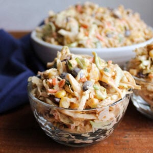 Small glass bowl filled with creamy coleslaw with corn, black beans, and chili lime dressing, ready to eat.