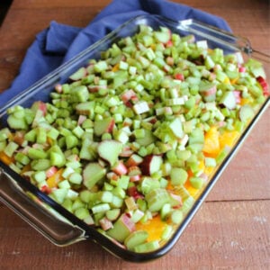 Chopped peaches and sliced rhubarb in a glass 9x13-inch baking dish.