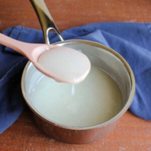 Spoon filled with thickened sugar and cornstarch mixture over the saucepan it was cooked in.