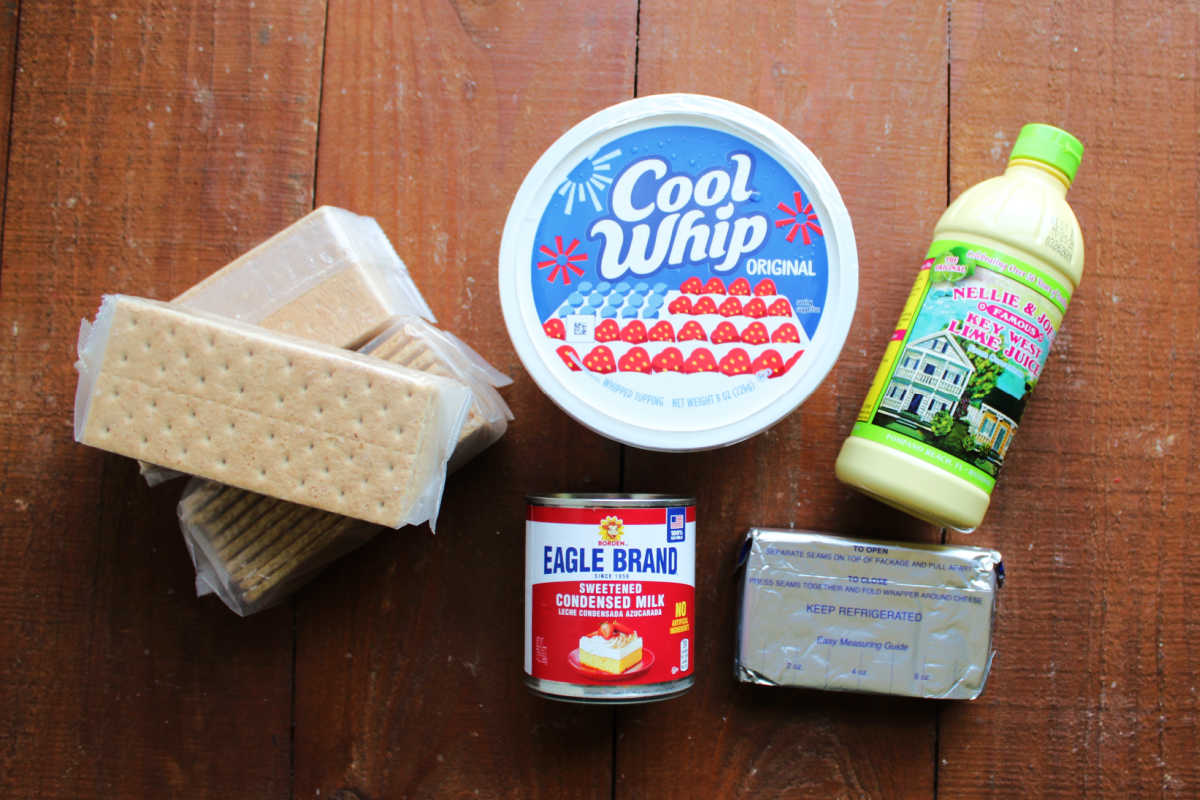 Ingredients including graham crackers, Cool Whip, key lime juice, cream cheese and sweetened condensed milk, ready to be made into key lime eclair cake. 