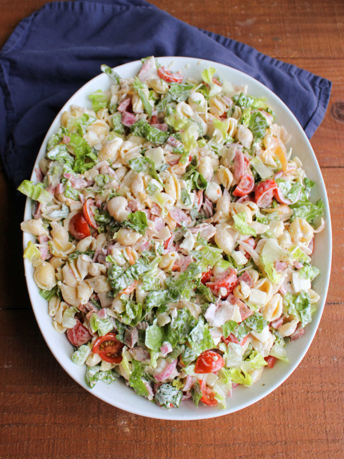 Grinder Pasta Salad 9 Large serving bowl of Italian grinder macaroni salad with lots of fresh veggies, meats, and cheeses with pasta and a light coating of creamy dressing.