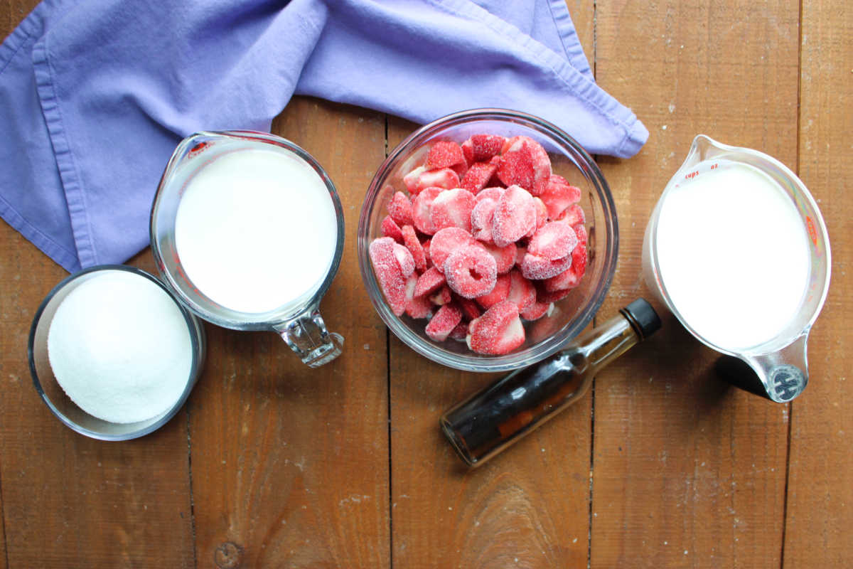 Homemade Strawberry Ice Cream Without Eggs 6 Ingredients including sugar, milk, strawberries, vanilla, and cream ready to be made into strawberry ice cream.