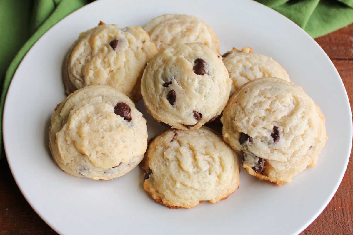 Close up of chocolate chip condensed milk cookies showing their rounded shape with light color, slightly golden edges, and lots of chocolate chips inside. 