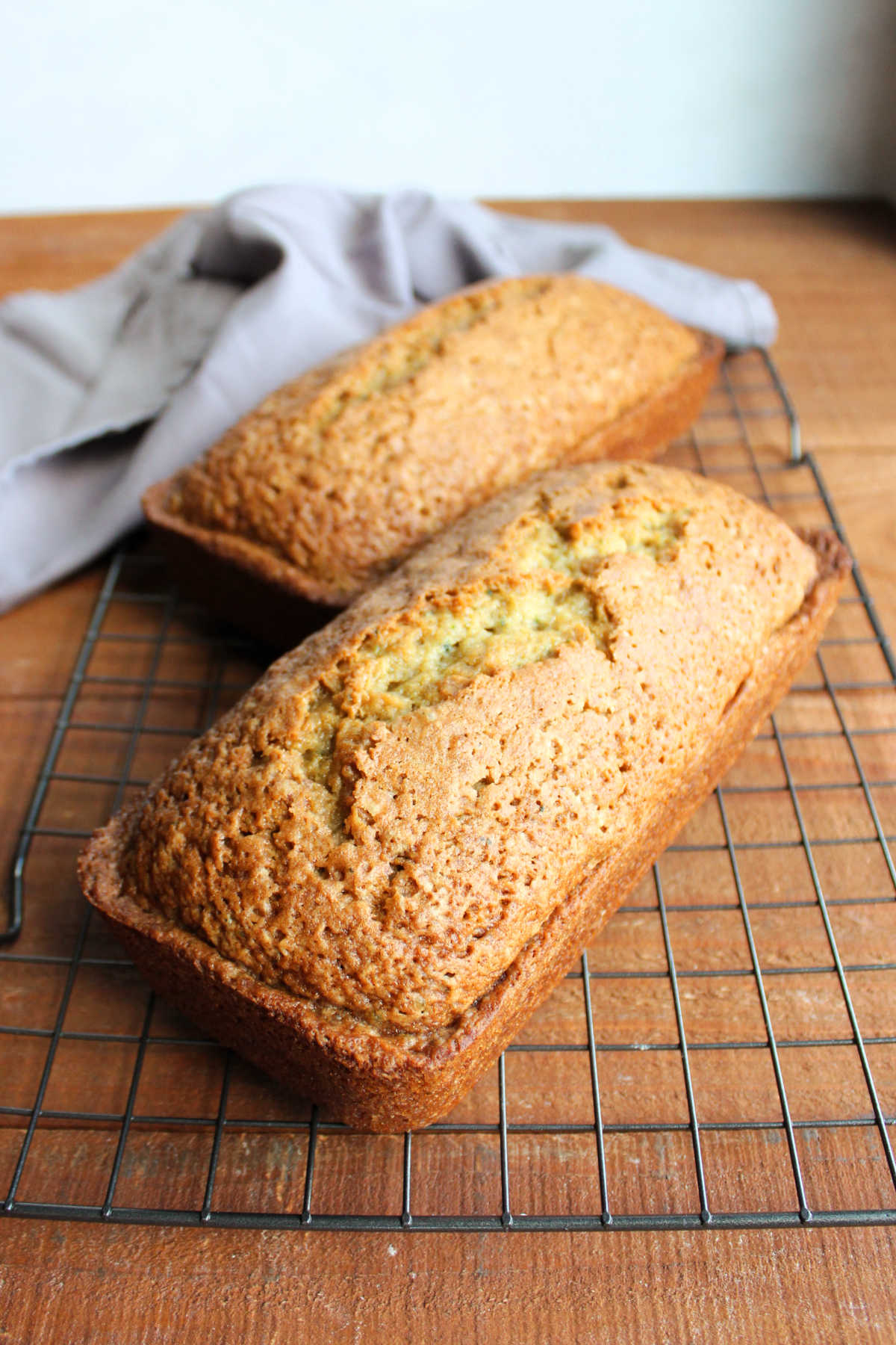 Two loaves of cucumber bread cooling on wire racks. 