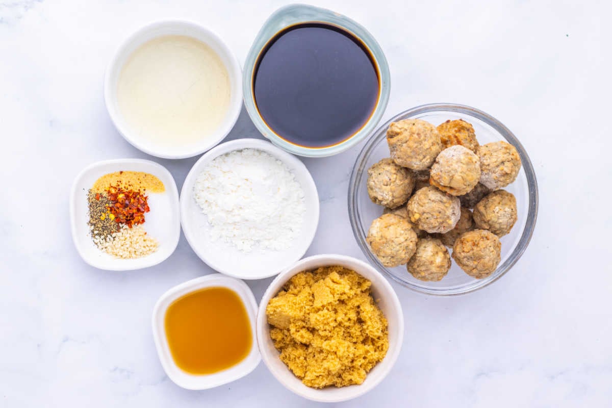 Ingredients including frozen meatballs, soy sauce, brown sugar, sesame oils, seasonings, and cornstarch ready to be made into Asian style Mongolian meatballs. 