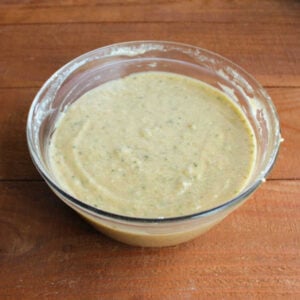 Bowl of cucumber bread batter with tiny flecks of green throughout.