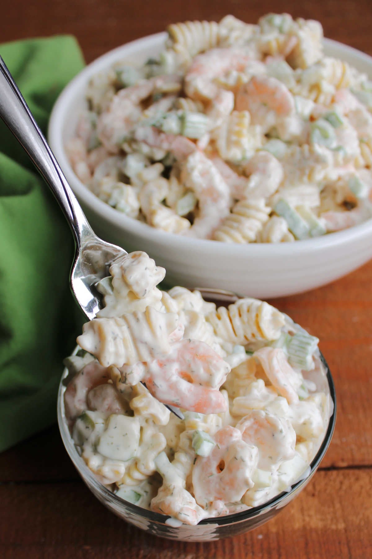 Shrimp Pasta Salad 11 Bite of creamy shrimp macaroni salad on fork showing light dressing with herbs, veggies, shrimp, and pasta.