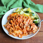 Plate filled with saucy lazy lasagna with meat sauce and melted Velveeta cheese served with roasted zucchini and summer squash.