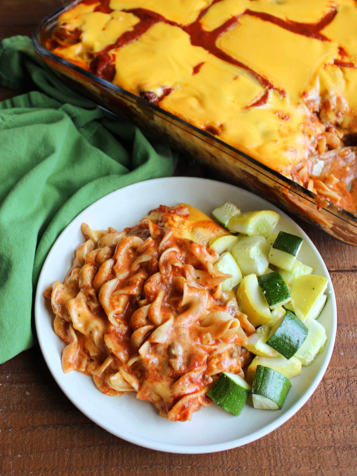 Mom's Lazy Lasagna With Velveeta 6 Serving of Mom's lazy lasagna on plate with roasted zucchini with the pan of more lazy lasagna topped with melted Velveeta nearby.