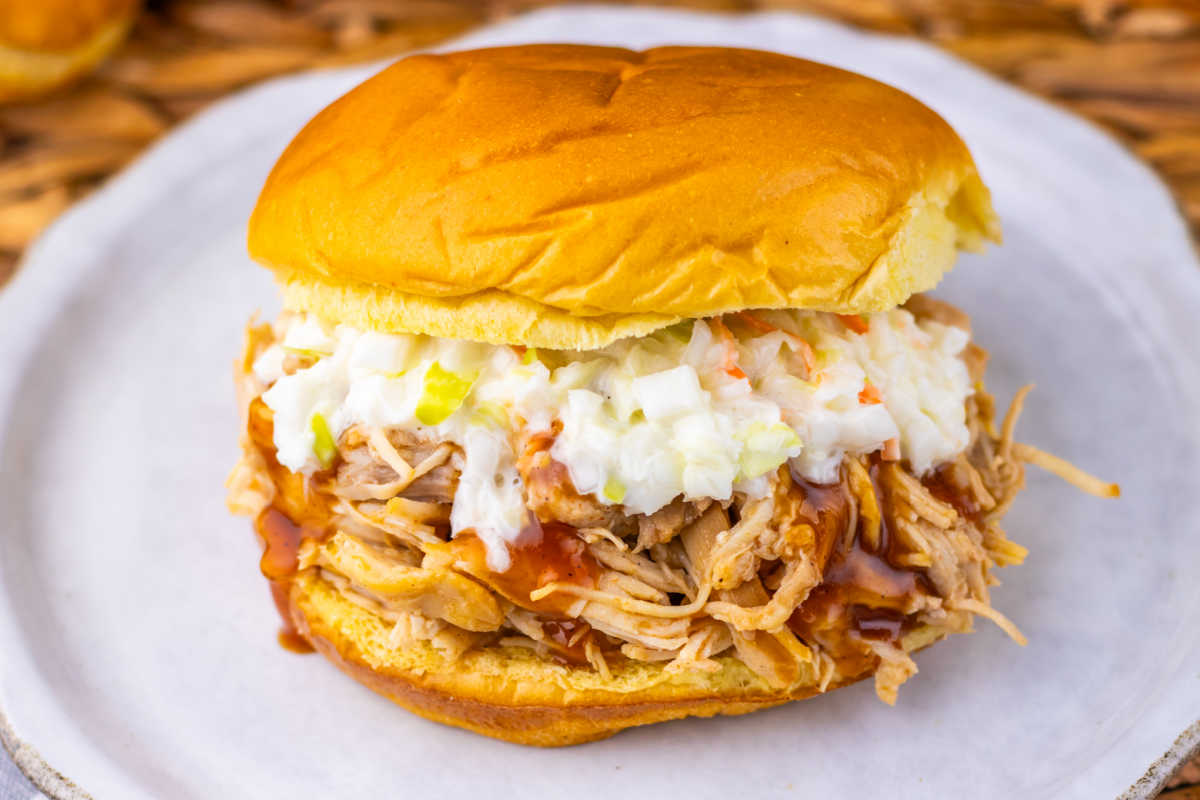 BBQ pulled chicken sandwich on Brioche bun with some coleslaw on top of the bbq chicken. 