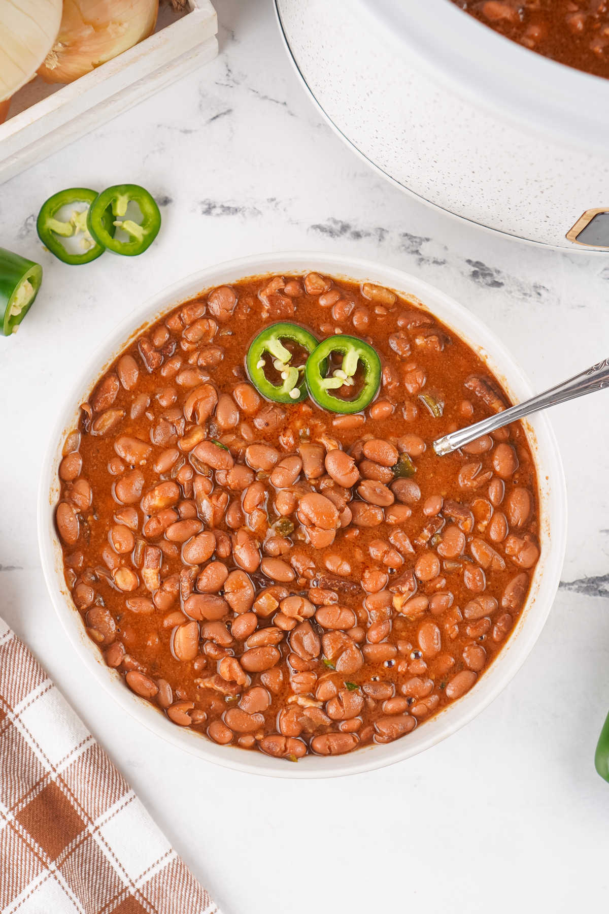 Crockpot Baked Beans With Dried Beans 9 Bowl of homemade baked beans from scratch next to the crockpot they were cooked in.