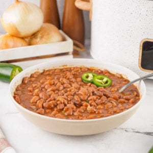 Crockpot Baked Beans With Dried Beans 11 Serving bowl filled with homemade baked beans made from dried beans in a crockpot.