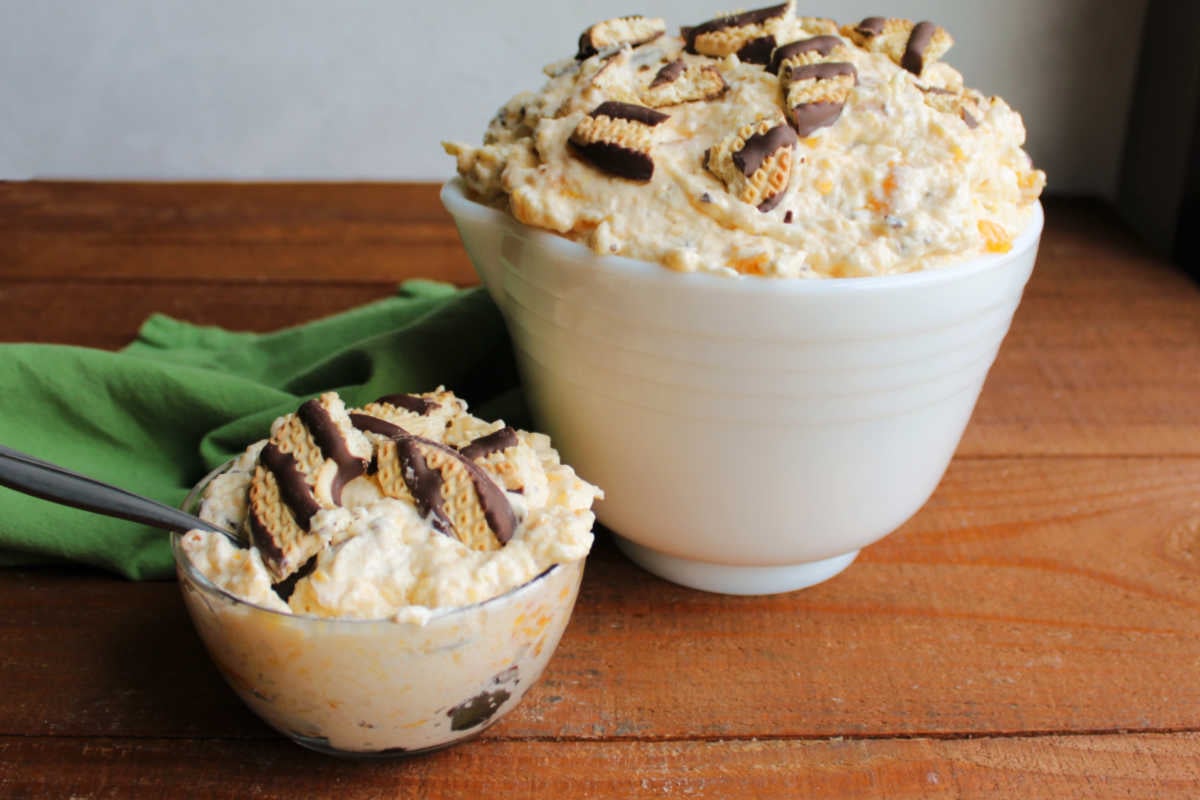 Small bowl filled with a serving of cookie salad next to a vintage serving bowl with more cookie salad inside, ready to eat. 