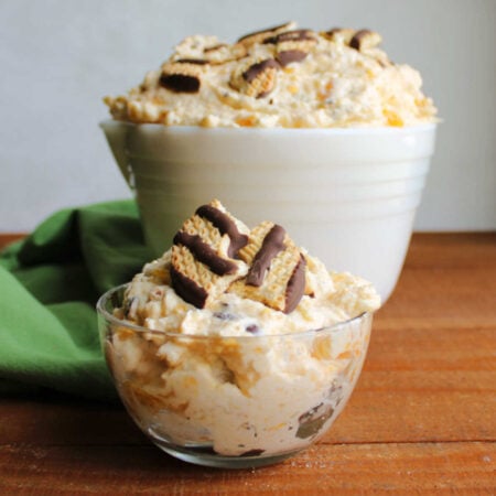 Cookie Salad 1 Small glass of pudding salad with bits of fruit and cookies in a creamy pudding based dressing topped with more pieces of fudge stripe cookies, ready to eat.