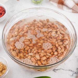 Crockpot Baked Beans With Dried Beans 12 Bowl of pinto beans soaking in bowl of water with baking soda.