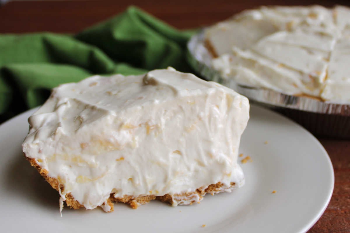 Close up of a piece of pineapple pie showing light and airy creamy filling with crushed pineapple throughout. 