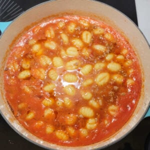 Gnocchi starting to float to the top of the tomato soup mixture.