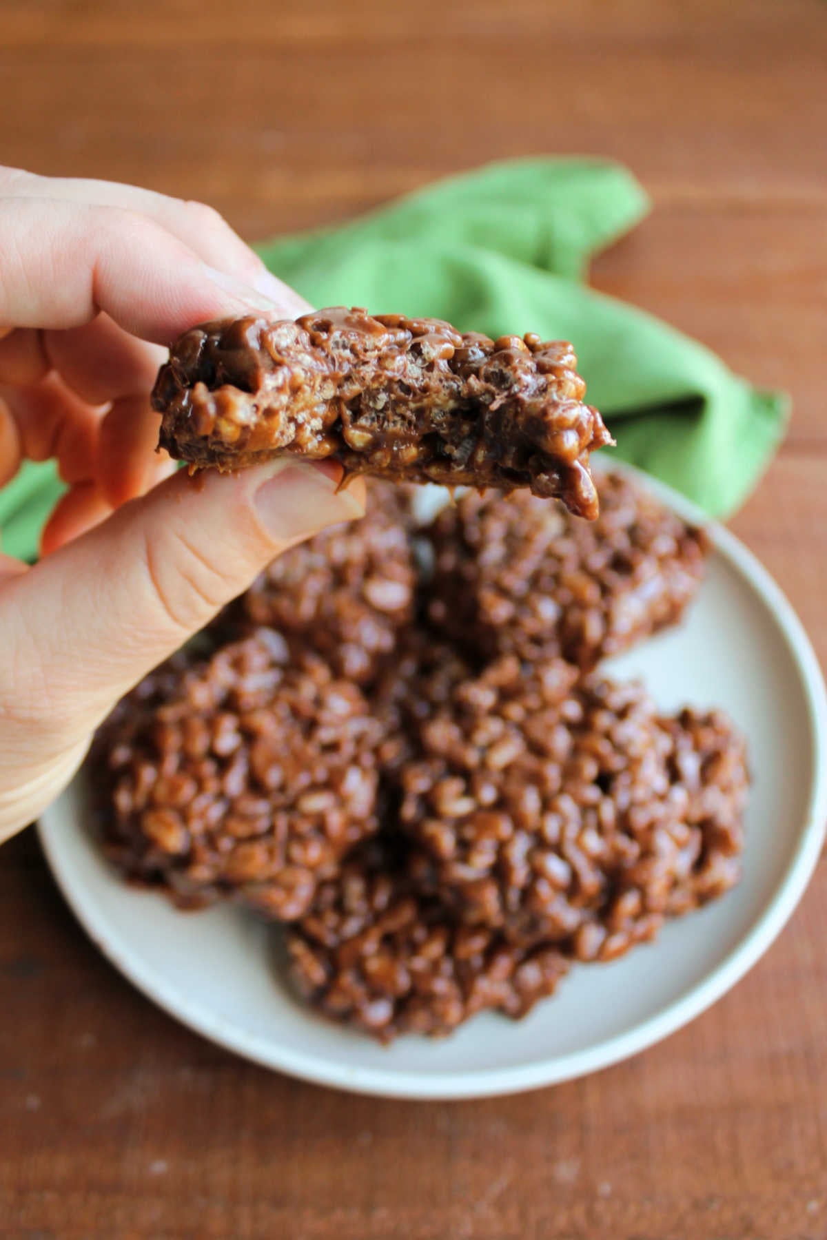 Homemade Star Crunch 11 Hand holding a homemade star crunch that is missing a bite showing the chewy chocolate texture with bits of crisp rice cereal throughout.