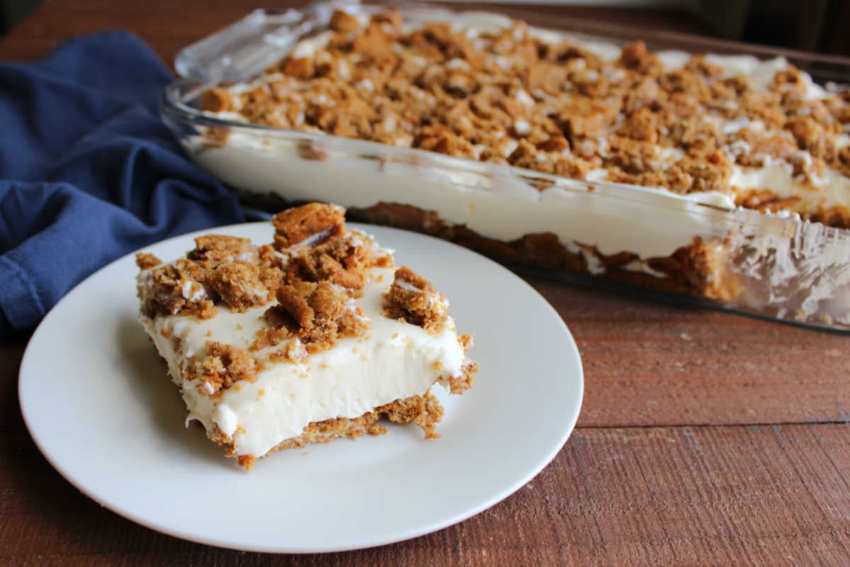 Piece of oatmeal creme pie no bake cheesecake on plate with dish of more cheesecake in the background. 