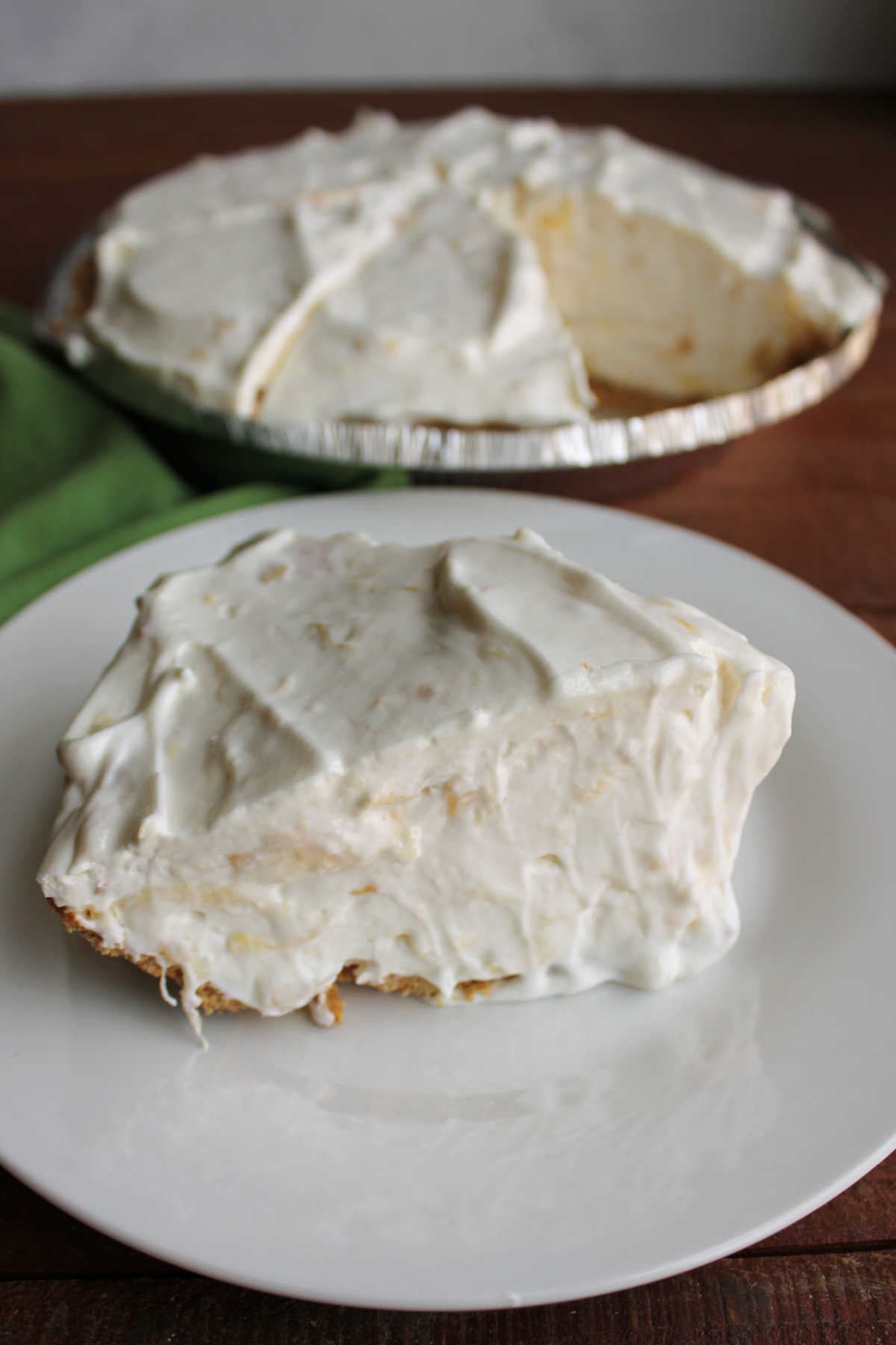 Piece of pineapple pie with lots of creamy filling on plate, ready to eat. 