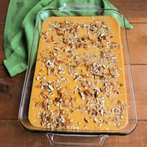 Pecan pieces sprinkled over pumpkin layer in pan.