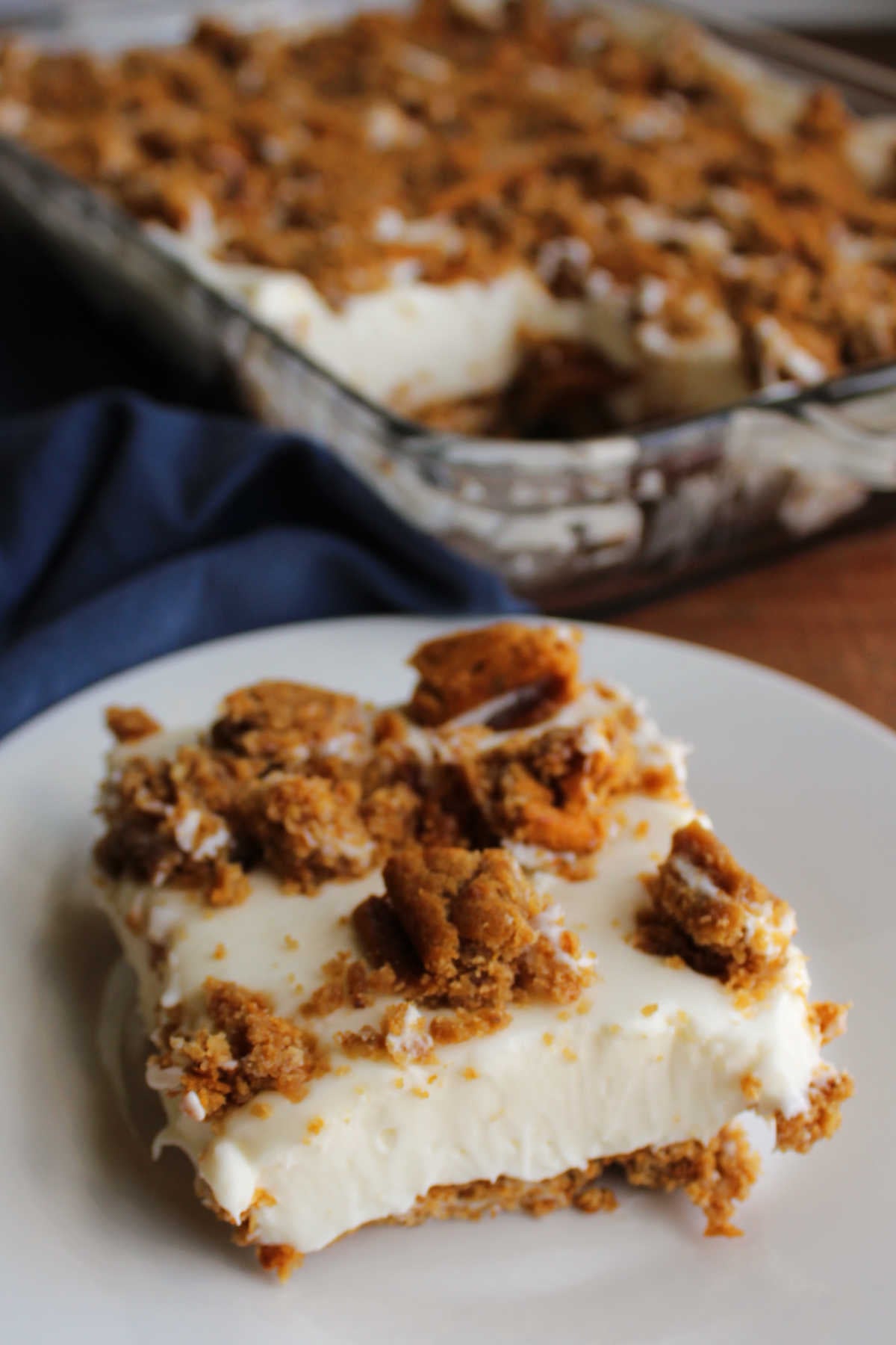 Piece of oatmeal cream pie cheesecake on plate showing creamy no bake filling and bits of the snack cake on top and underneath as a crust. 