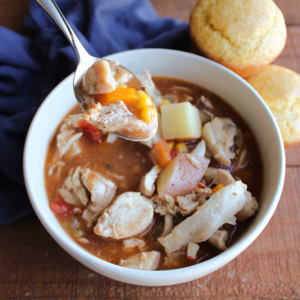 Chunky bite of southern style rabbit stew on a spoon, ready to eat. 