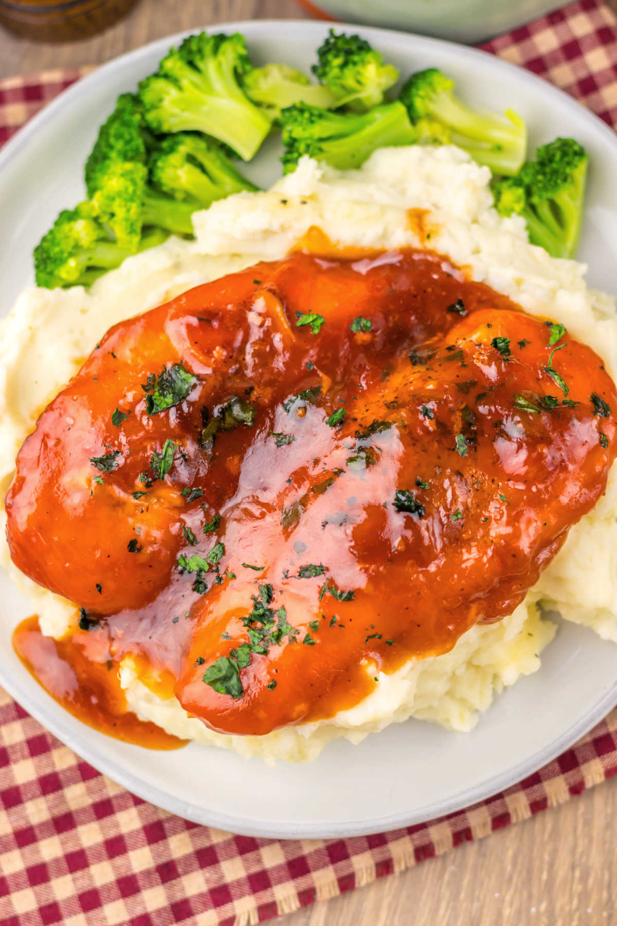 Chicken breasts coated in thick red sauce made from Catalina dressing served over mashed potatoes with a side of steamed broccoli. 