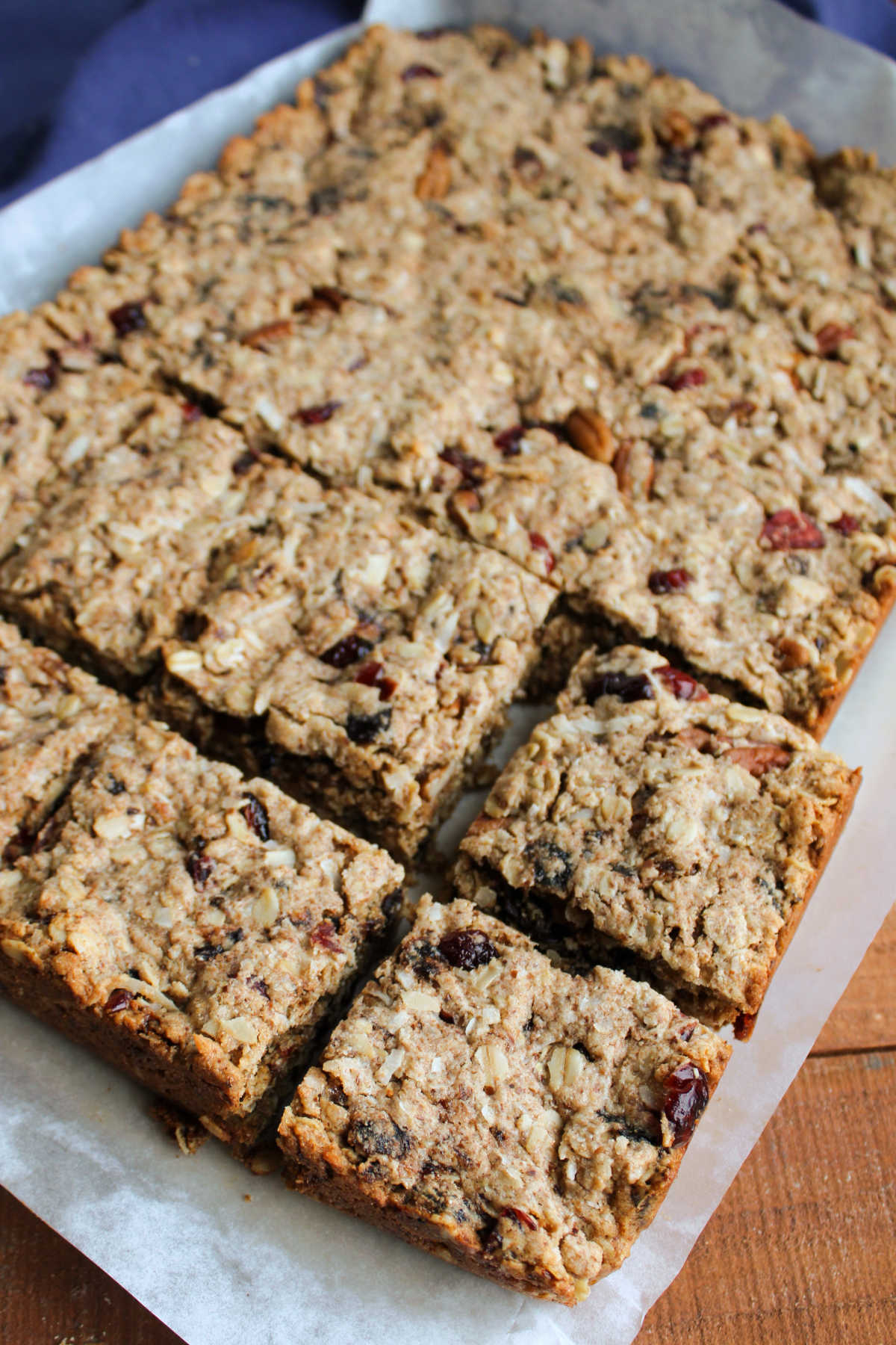 Cutting board with cooled trail mix bars getting cut into squares. 