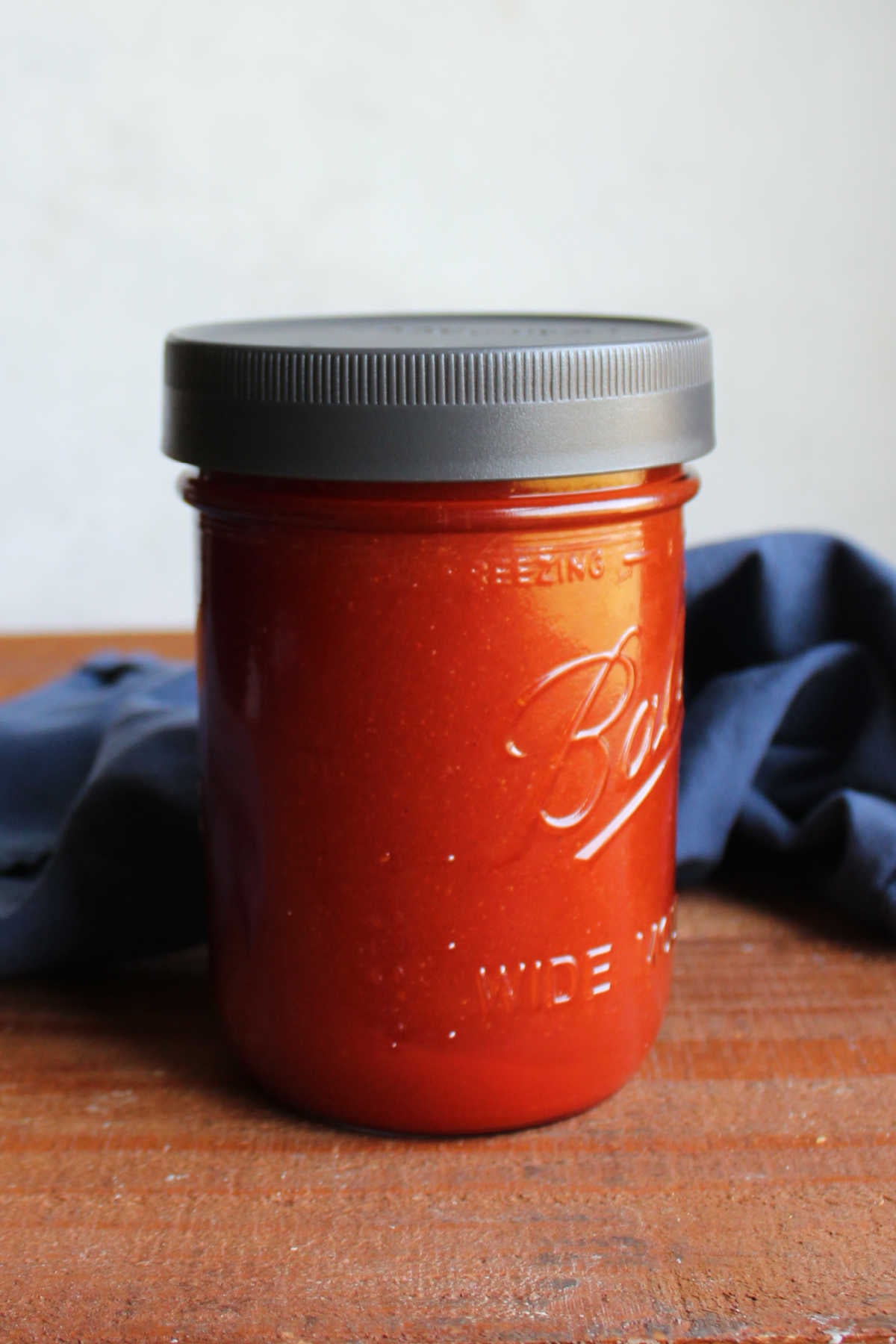 Ball jar filled with red homemade catalina dressing ready to be used.