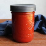 Ball jar filled with red homemade catalina dressing ready to be used.